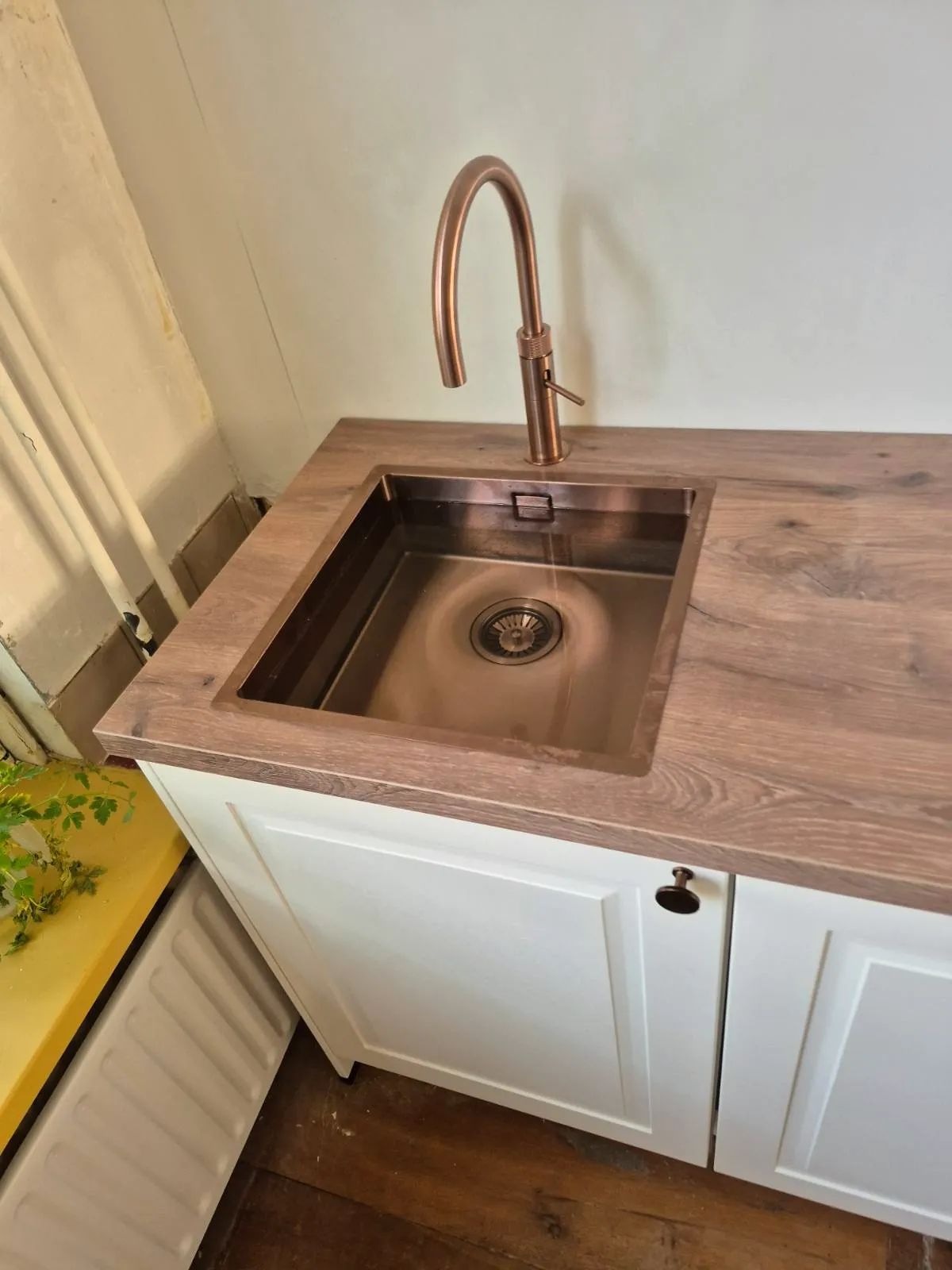 Koperen spoelbak en kraan in een eikenhouten werkblad
