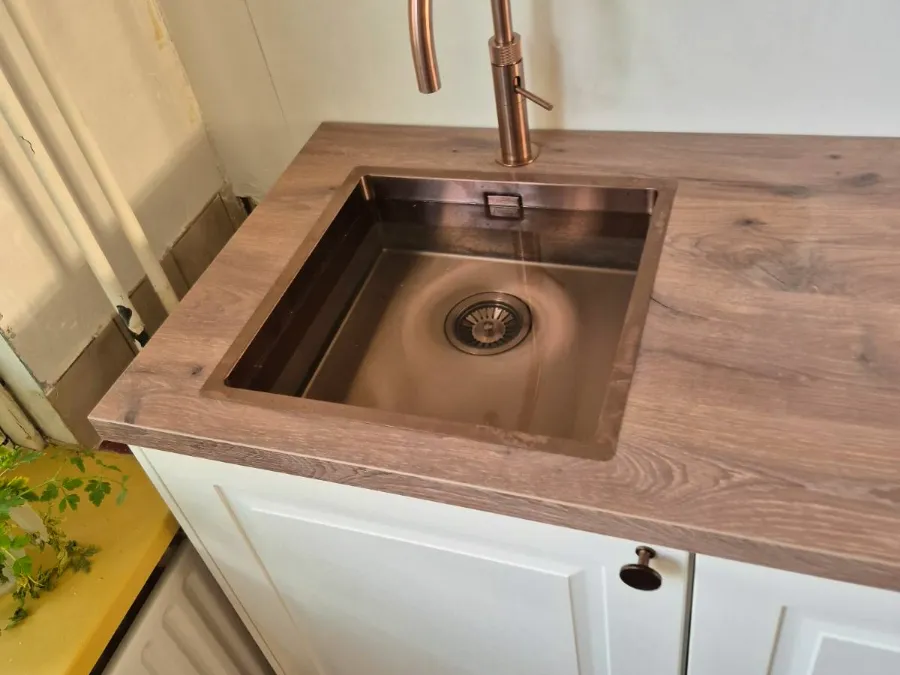 Koperen spoelbak en kraan in een eikenhouten werkblad