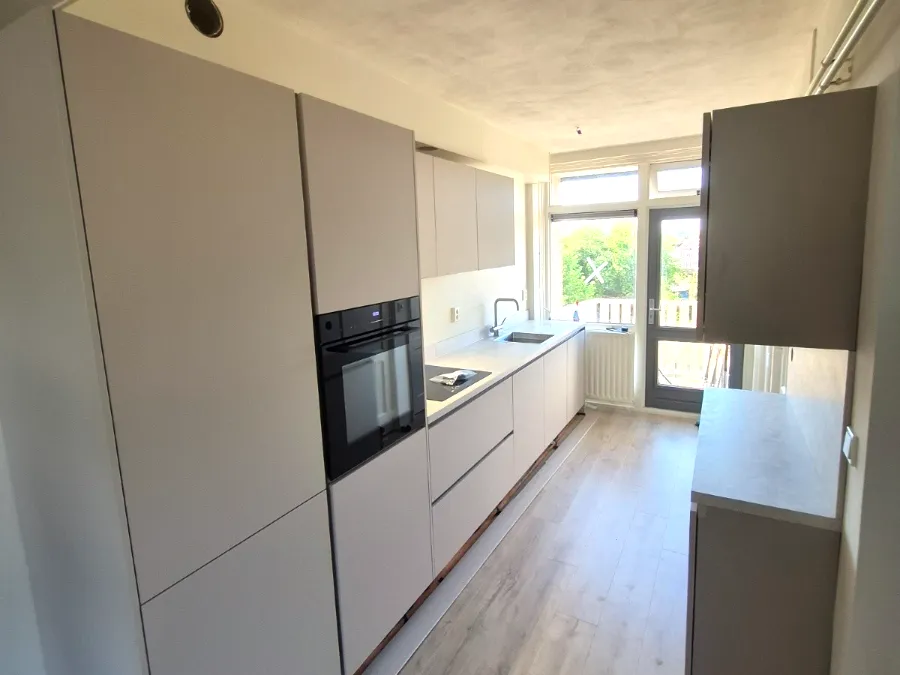 Lichte greeploze keuken met kastenwand