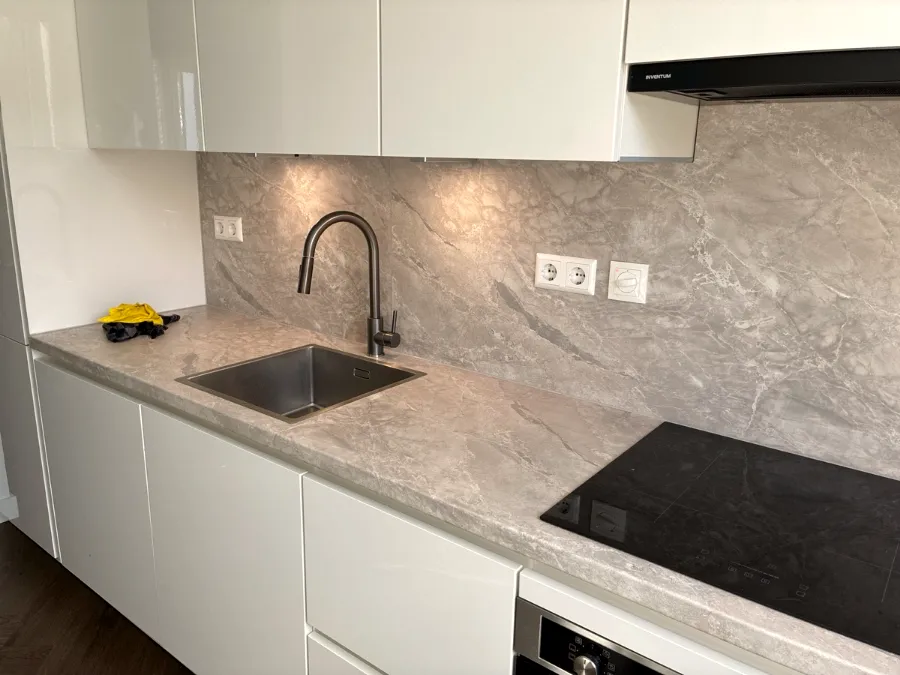 Hoogglans witte keuken met achterwand in natuursteenlook