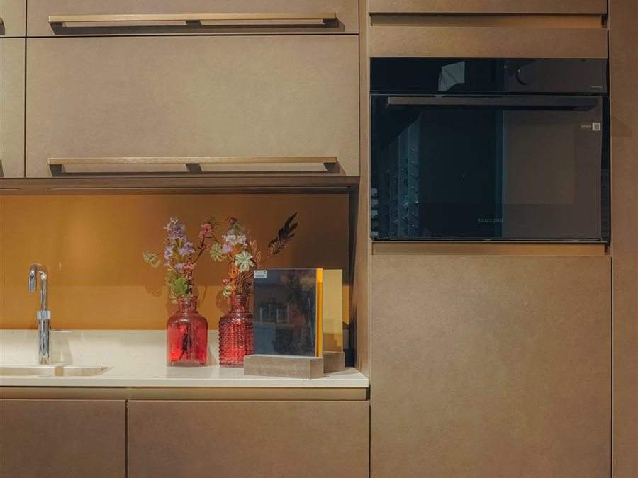 Keukenwand met oranje glazen achterwand