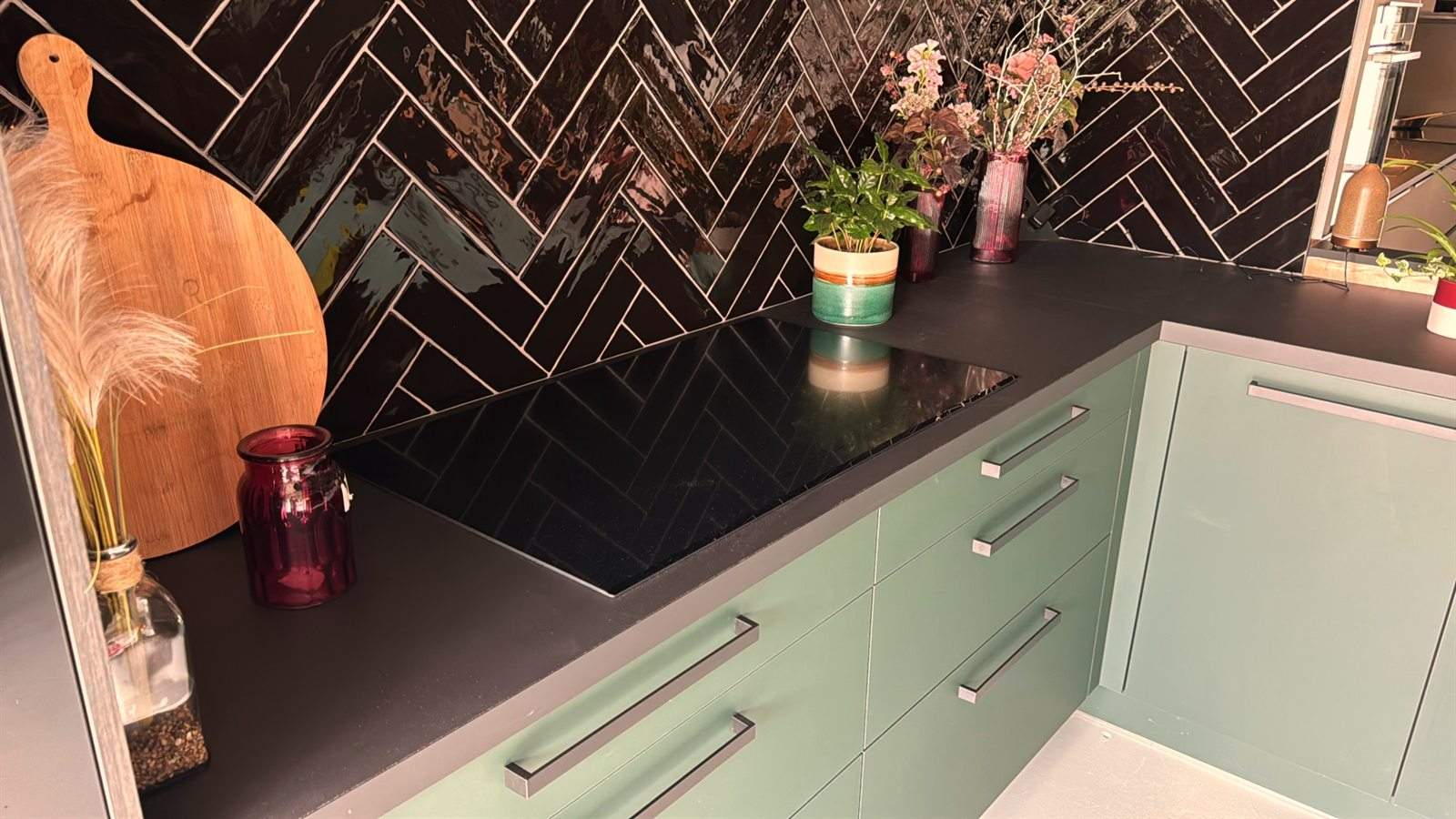 Groene keuken met een visgraat tegelwand