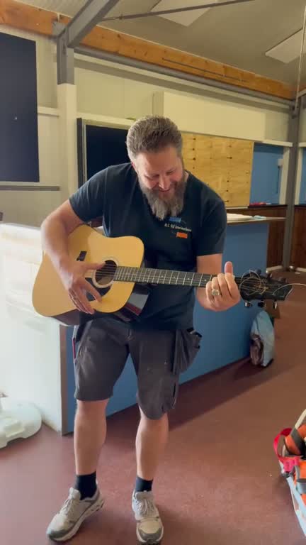 Herman speelt gitaar in de werkplaats